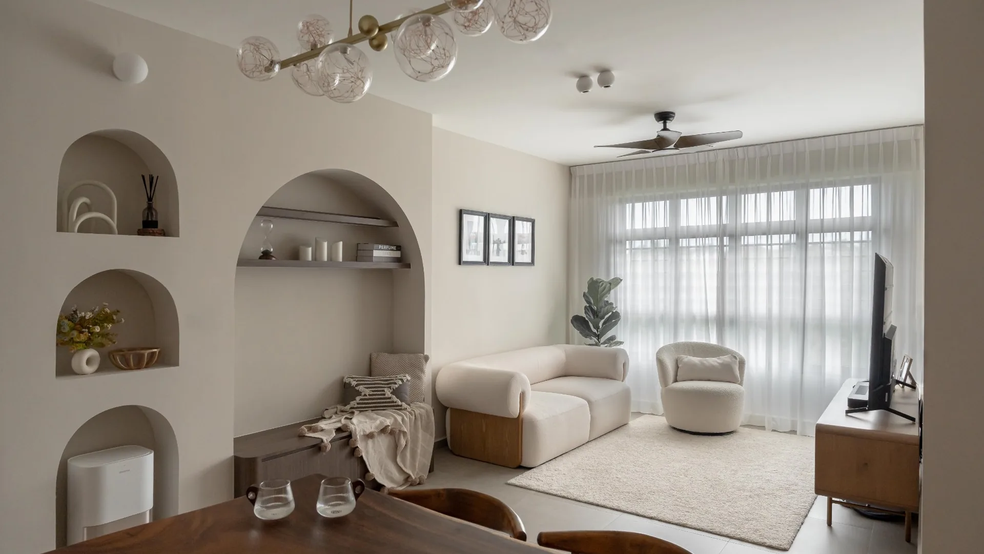 Open-concept 5 room BTO living area with arched niches and warm neutral palette by 6AM Spaces